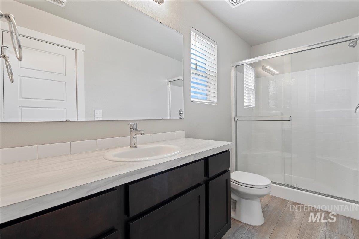 2487 East Goldstone Street Meridian, ID 83642 - Photo 15 of 25 Full bathroom with a shower stall, vanity, and light wood-type flooring