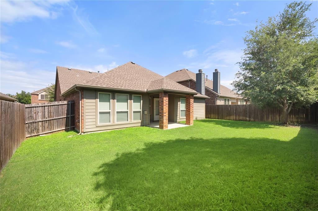 520 Rustic Oak Lane McKinney, TX 75072 - Photo 25 of 30 Spacious backyard with a covered patio, extensive lawn, mature tree, and privacy fencing