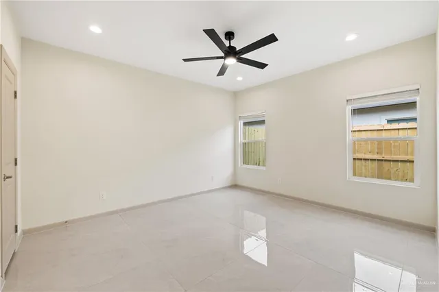 an empty room with a window and a ceiling fan