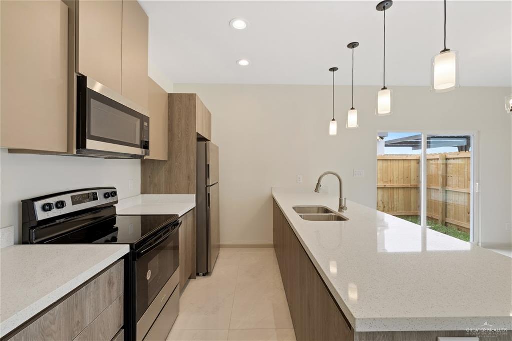 1804 West Violet Drive, Unit 3 Pharr, TX 78577 - Photo 6 of 15 a kitchen that has a sink a stove and a wooden floor