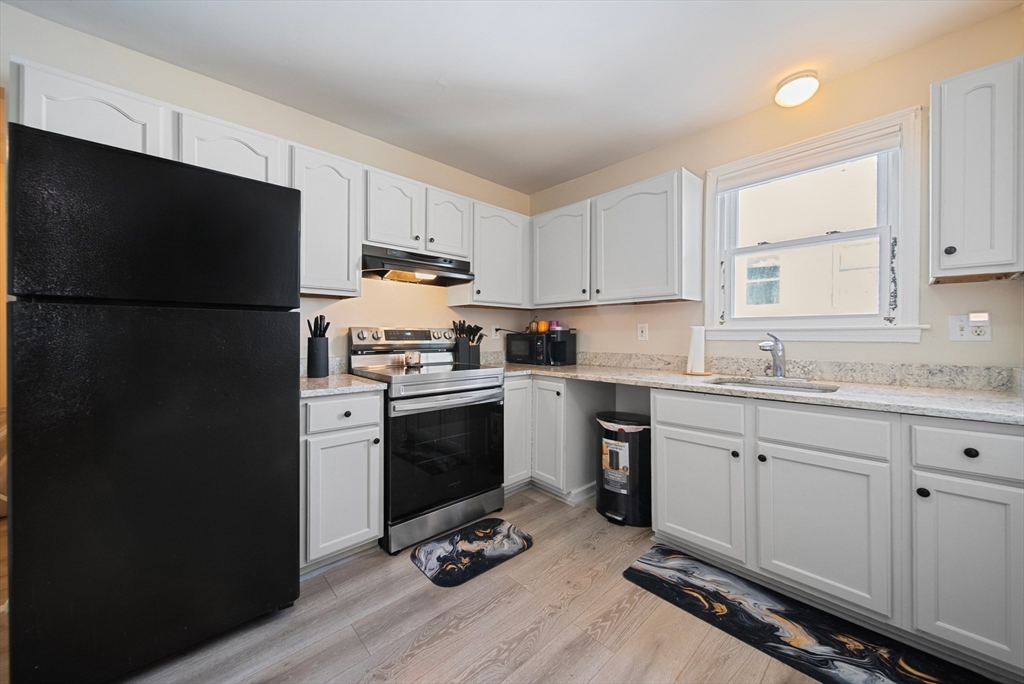 40 Bellevue Avenue Haverhill, MA 01832 - Photo 22 of 38 a kitchen with a refrigerator stove and white cabinets