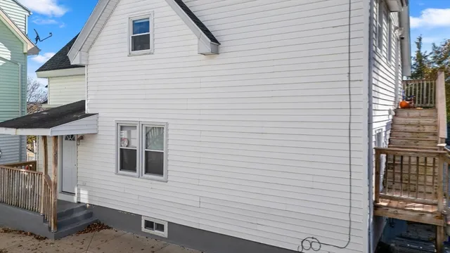 a view of a house with a small yard and large tree