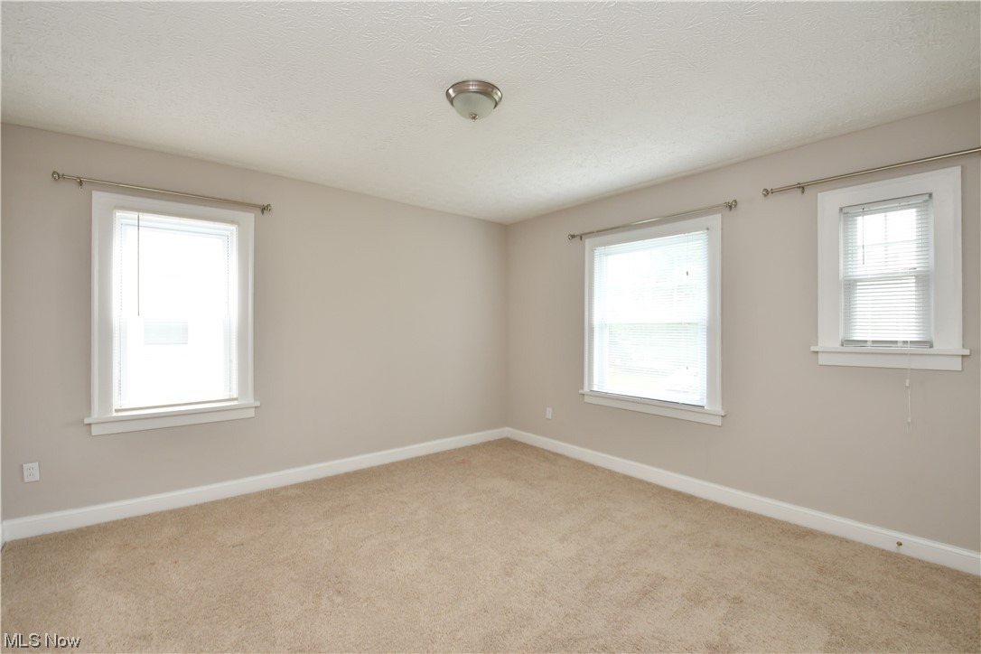 3347 Cedarbrook Road Cleveland, OH 44118 - Photo 14 of 22 Empty room featuring light carpet and a textured ceiling