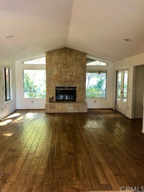 Cathedral Ceiling and large windows flank this beautiful fireplace