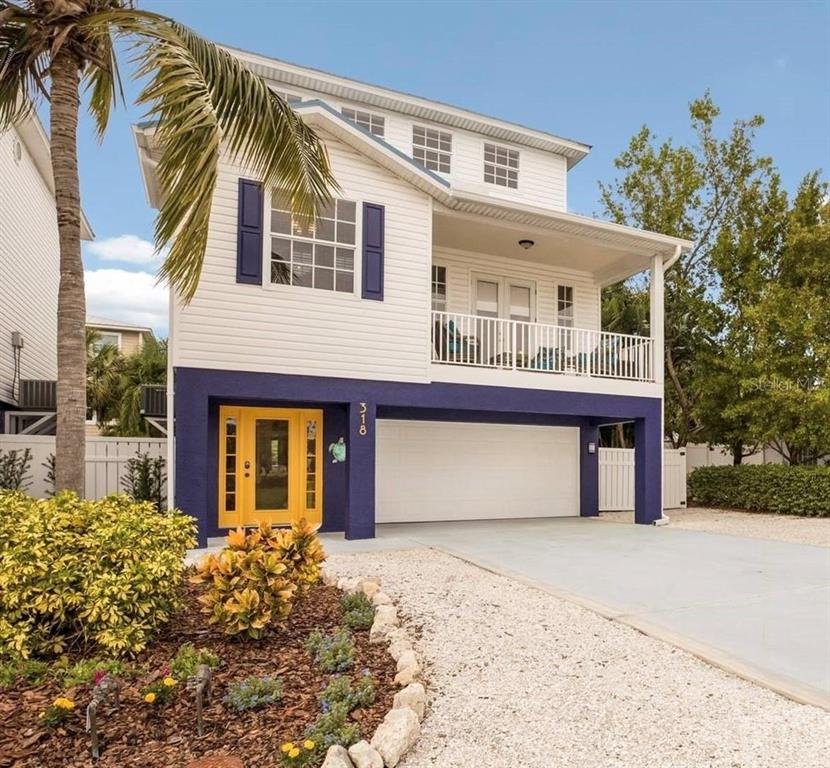 318 64th Street Holmes Beach, FL 34217 - Photo 1 of 33 a front view of a house with a garden and entryway