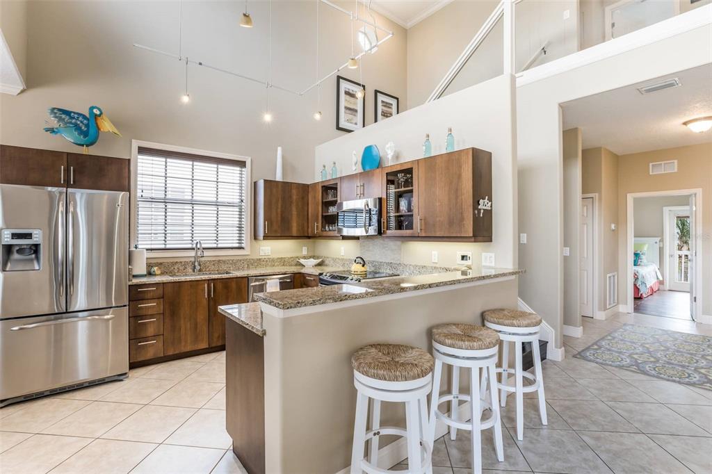 318 64th Street Holmes Beach, FL 34217 - Photo 11 of 33 a kitchen with a sink a refrigerator and chairs