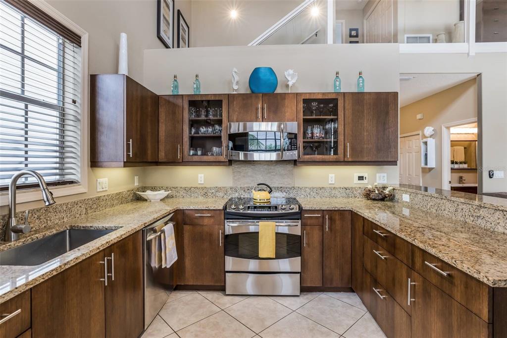 318 64th Street Holmes Beach, FL 34217 - Photo 13 of 33 a kitchen with stainless steel appliances granite countertop a sink a stove and cabinets