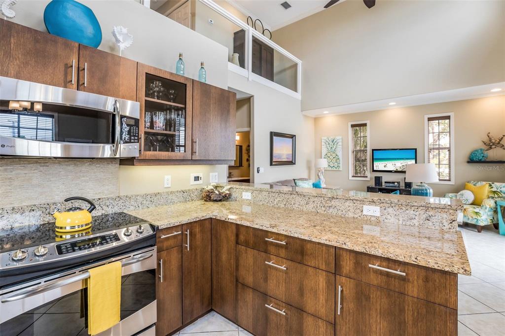 318 64th Street Holmes Beach, FL 34217 - Photo 14 of 33 a kitchen with stainless steel appliances granite countertop a stove a sink and a microwave