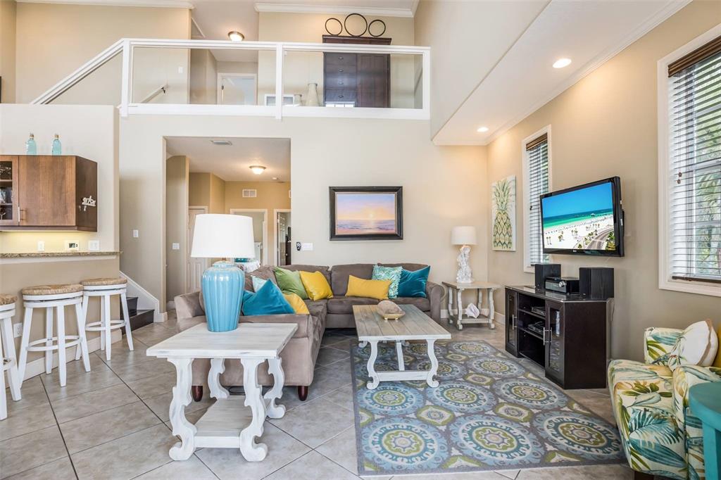 318 64th Street Holmes Beach, FL 34217 - Photo 10 of 33 a living room with furniture a flat screen tv and kitchen view