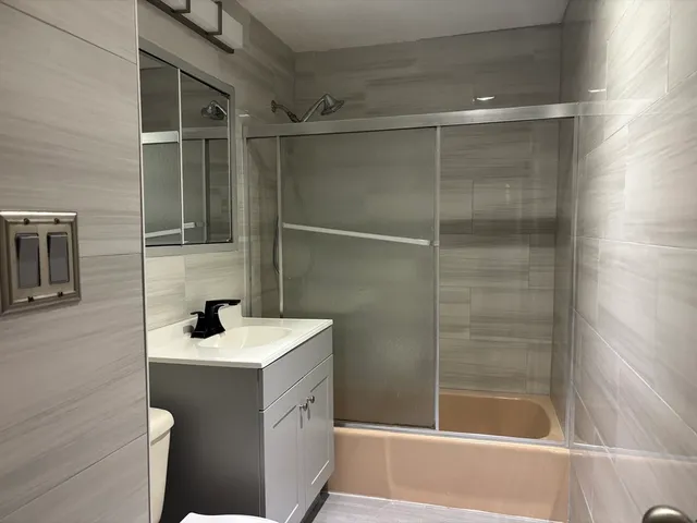 a bathroom with a sink mirror and shower