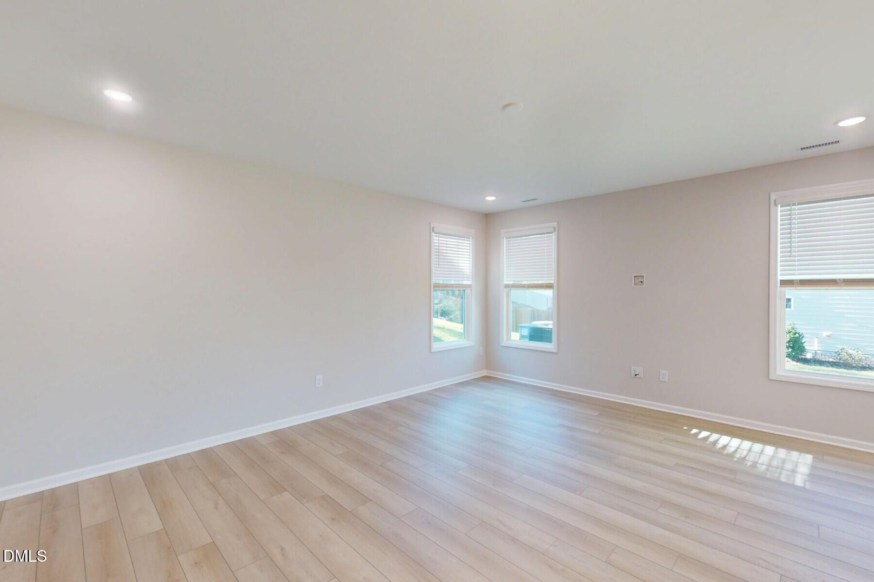 109 Tawny Slope Court, Unit 13 Raleigh, NC 27603 - Photo 17 of 48 a view of an empty room with wooden floor and a window