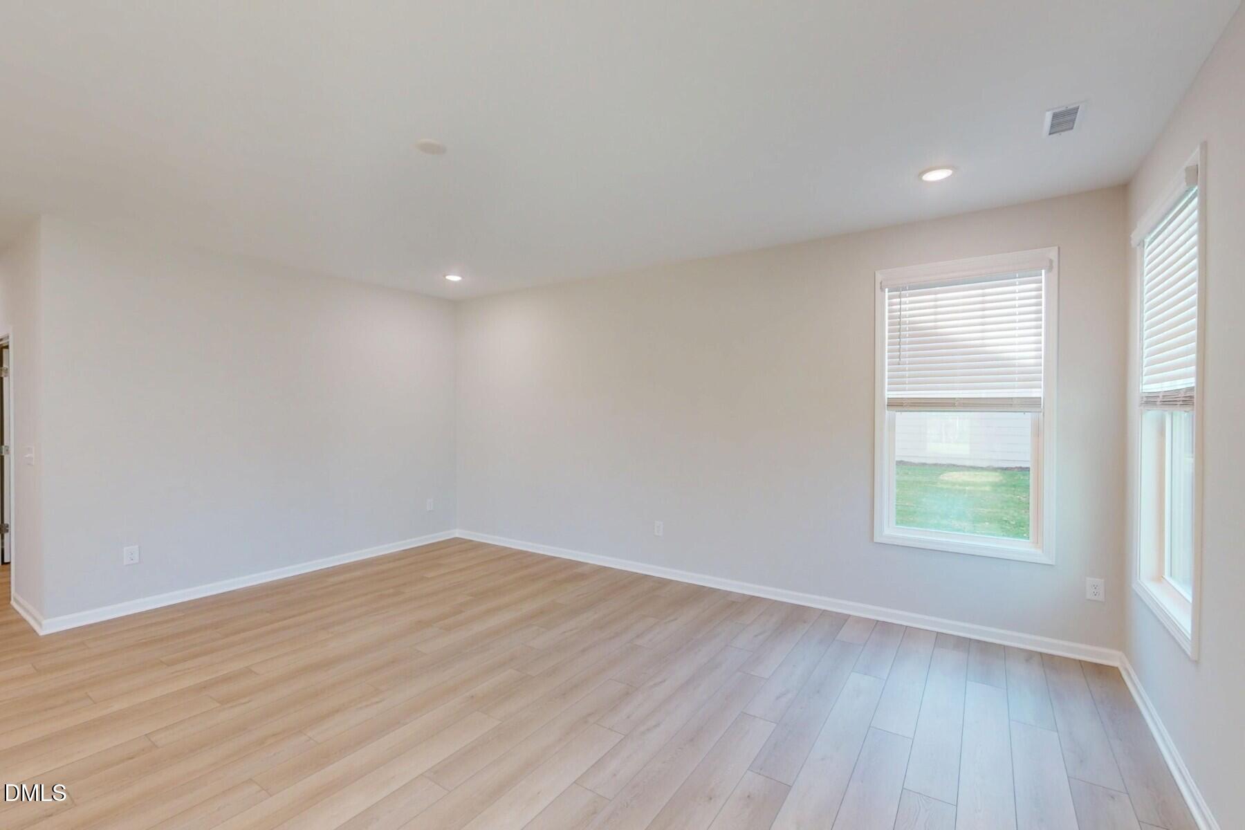 109 Tawny Slope Court, Unit 13 Raleigh, NC 27603 - Photo 18 of 48 an empty room with wooden floor and windows