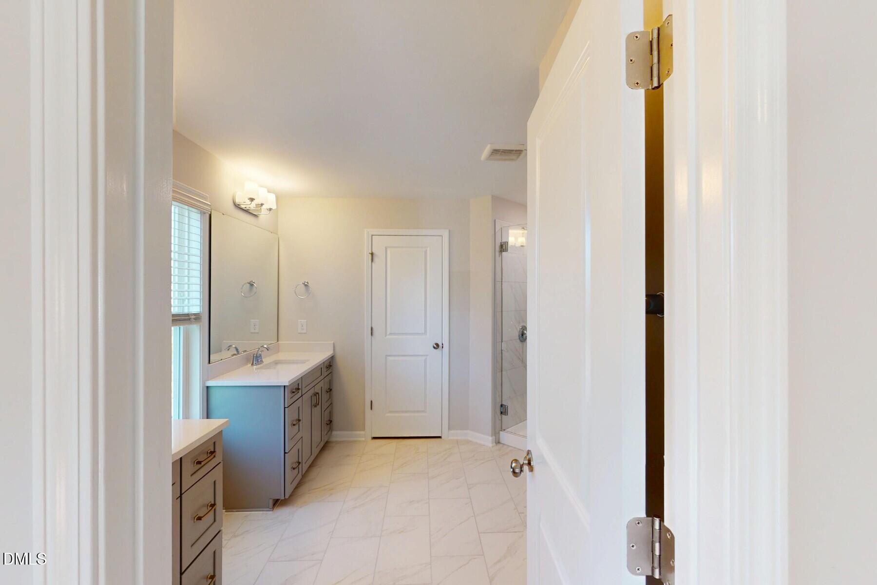 109 Tawny Slope Court, Unit 13 Raleigh, NC 27603 - Photo 21 of 48 a view of a bathroom with a sink and mirror