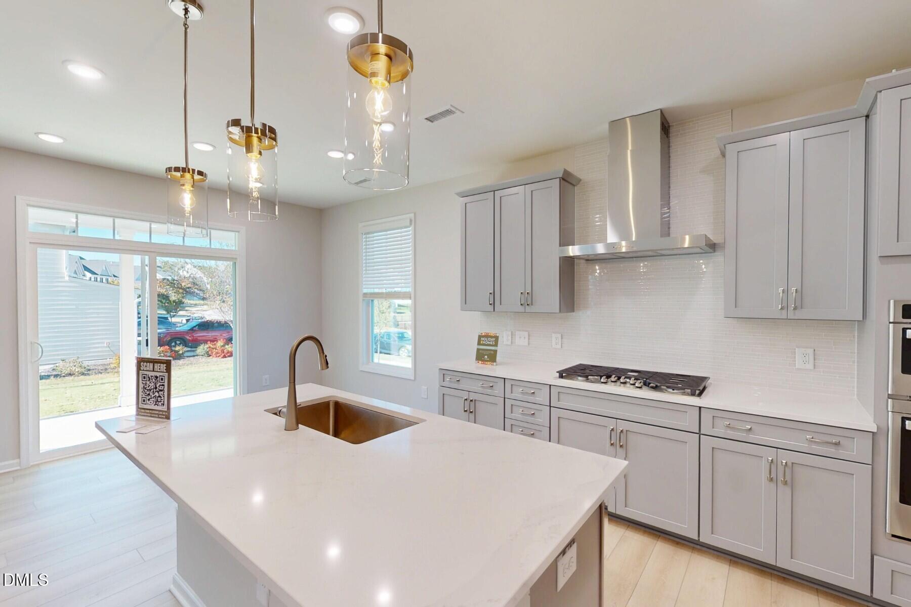 109 Tawny Slope Court, Unit 13 Raleigh, NC 27603 - Photo 4 of 48 a kitchen with white cabinets a sink dishwasher and a stove with wooden floor