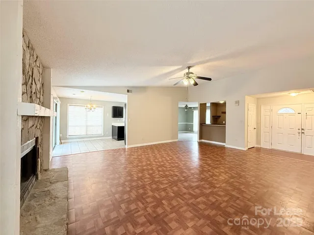 a view of an empty room with a fireplace and a window
