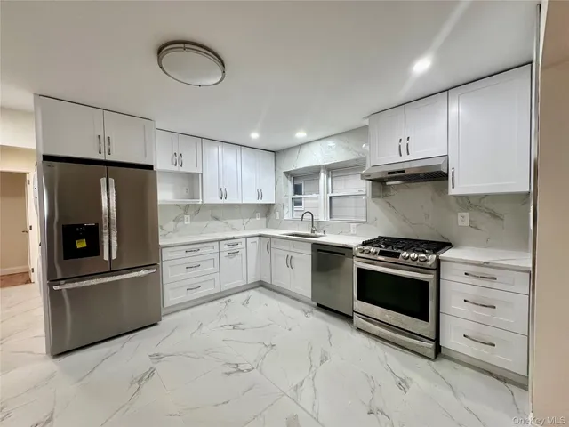 a kitchen with cabinets stainless steel appliances and window