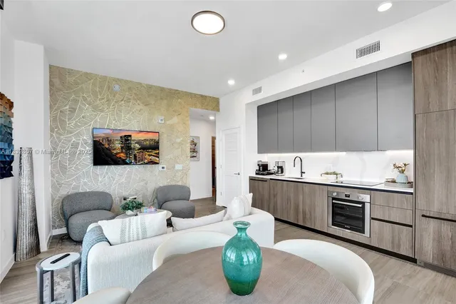 a living room with stainless steel appliances kitchen island granite countertop a couch and a view of living room