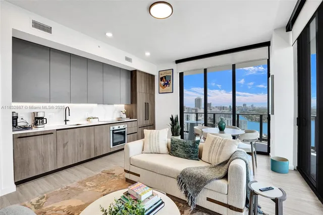 a kitchen with stainless steel appliances granite countertop a stove top oven a sink with dining table and chairs