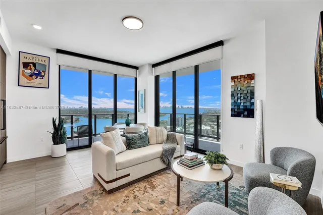 a living room with furniture and a floor to ceiling window