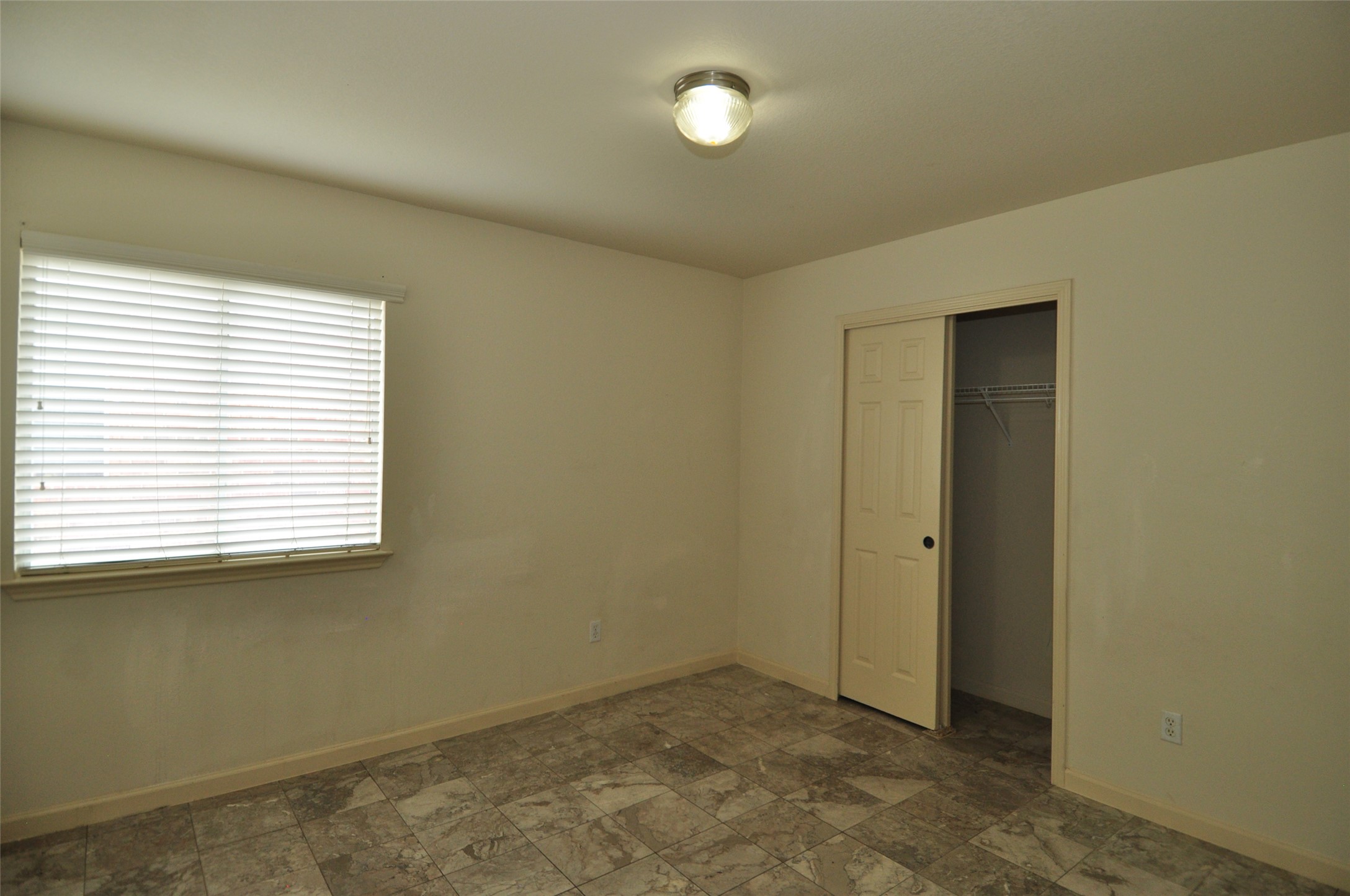 1409 Tea Leaf Drive Pflugerville, TX 78660 - Photo 14 of 18 A well-lit bedroom features durable tile flooring and convenient sliding closet doors.