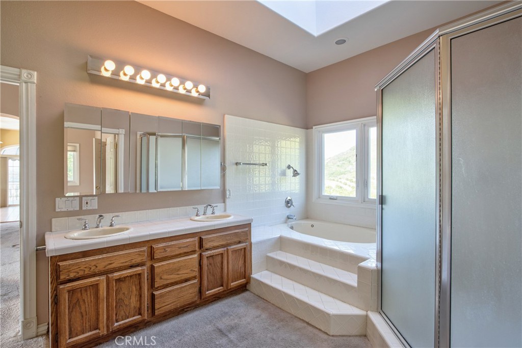 46856 El Prado Road Temecula, CA 92590 - Photo 61 of 75 a spacious bathroom with a shower a sink and a large mirror