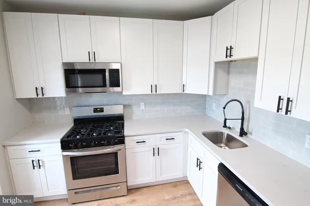 a kitchen with white cabinets and stainless steel appliances