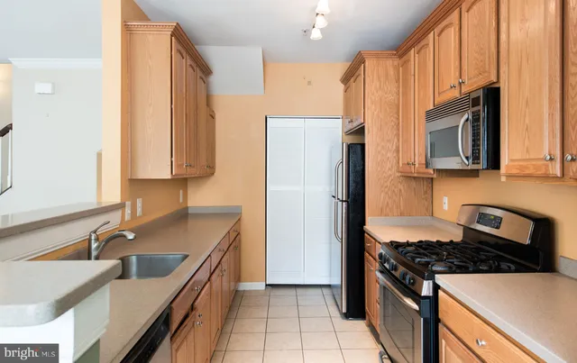 a kitchen with stainless steel appliances a stove a sink a microwave and refrigerator