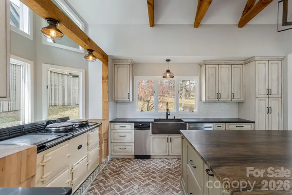 a kitchen with stainless steel appliances granite countertop a sink stove and cabinets