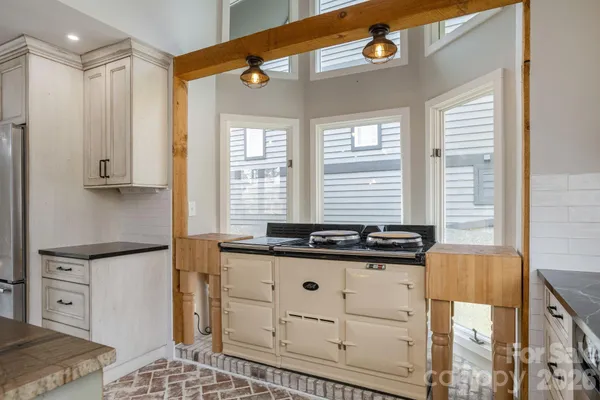 a kitchen with stainless steel appliances granite countertop a stove a sink and a refrigerator