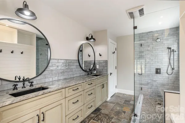 a bathroom with a sink a mirror and shower