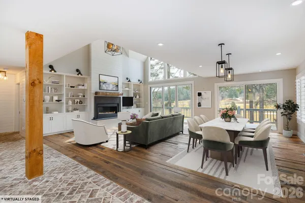 a living room with furniture kitchen view and a chandelier