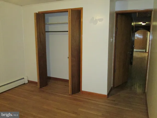 an empty room with wooden floor and closet