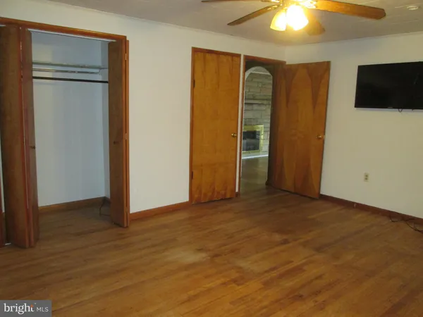 an empty room with closet and a flat screen tv