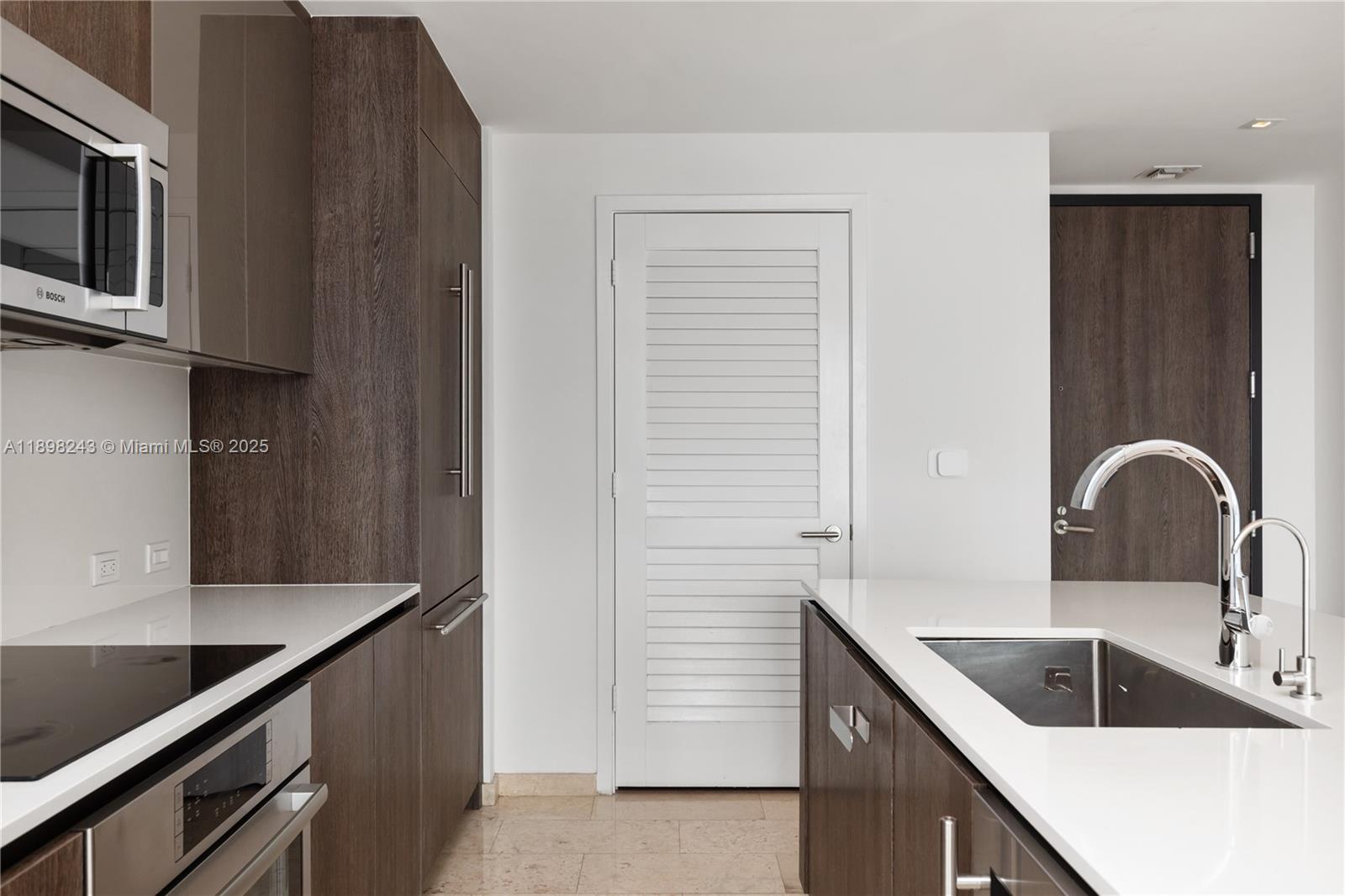 68 Southeast 6th Street, Unit 3906 Miami, FL 33131 - Photo 8 of 48 a kitchen with a sink and a microwave