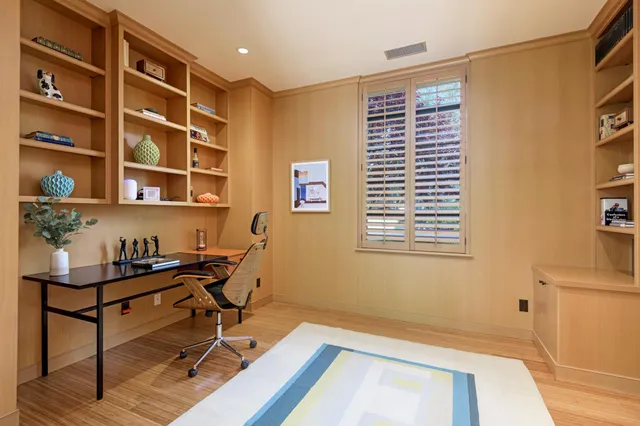 a view of a workspace with furniture and a window