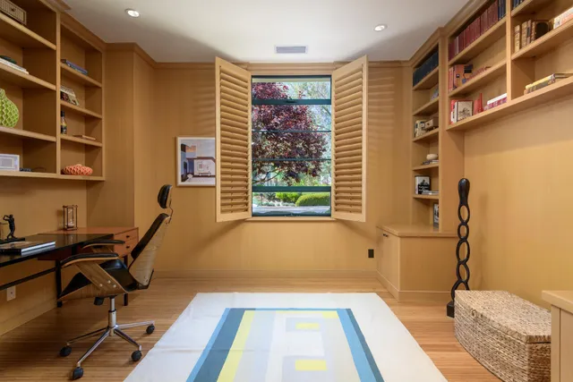 a view of a workspace with furniture and a window
