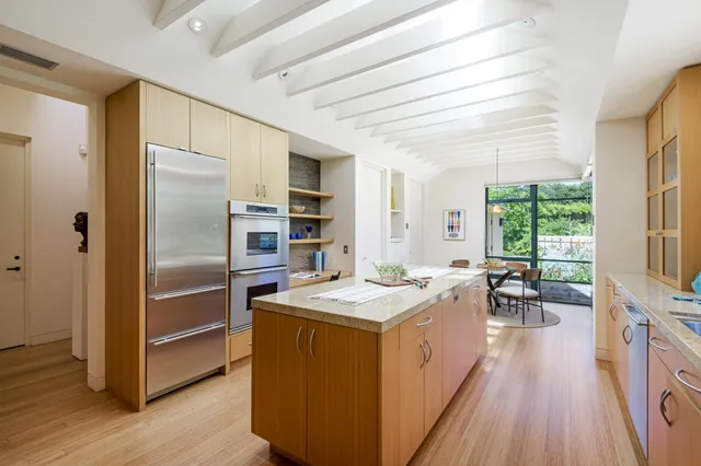 a kitchen that has a lot of cabinets a sink and appliances in it