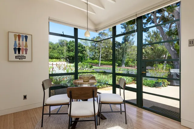 a dining room with a glass top table and chairs