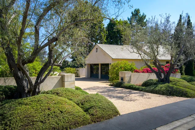 a front view of a house with a yard and trees