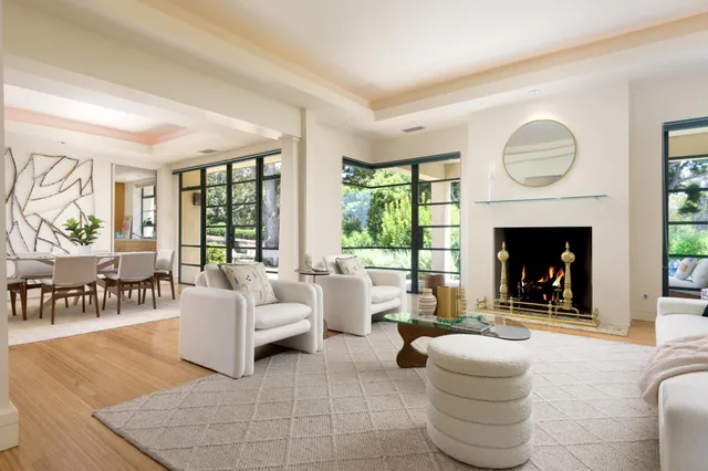 a living room with furniture a fireplace and a large window