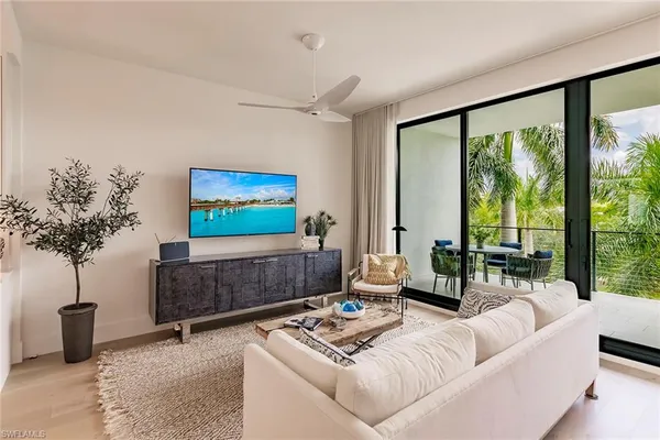 a living room with furniture a lamp and a potted plant