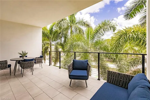 a balcony with wooden floor and outdoor seating