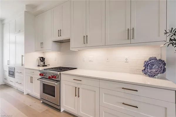 a kitchen with white cabinets and white appliances