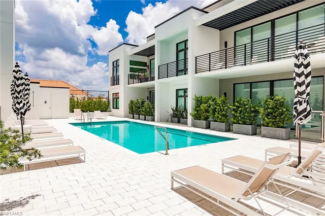 a view of a white building with a swimming pool