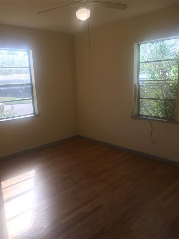 1614 Elmira Road Austin, TX 78721 - Photo 21 of 23 Unfurnished room with dark wood-style flooring, plenty of natural light, and a ceiling fan