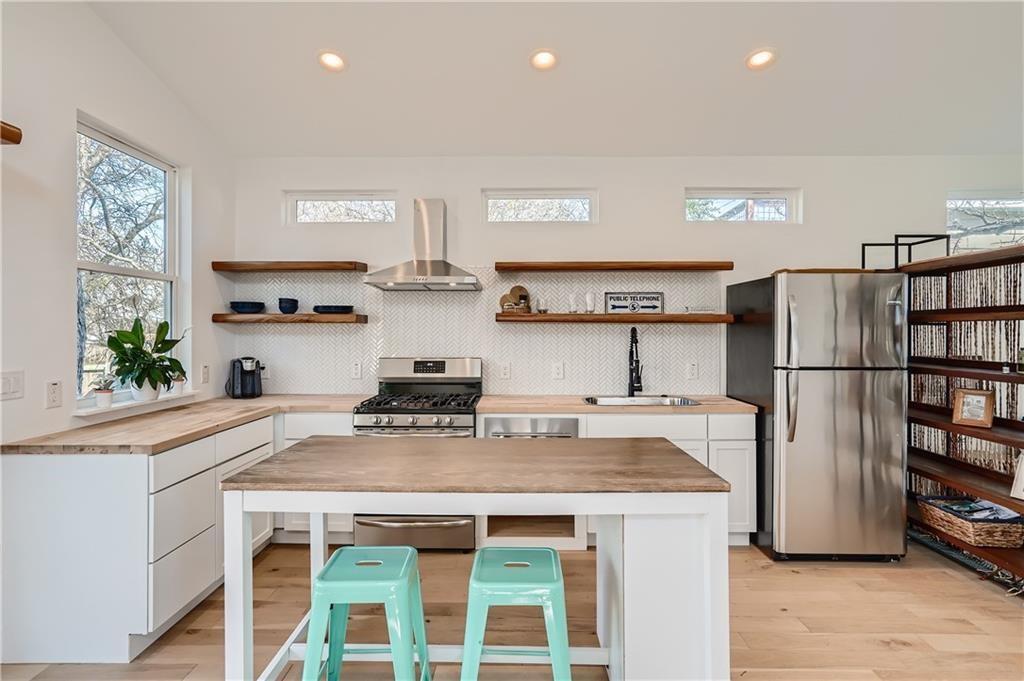 1614 Elmira Road Austin, TX 78721 - Photo 6 of 23 Kitchen featuring butcher block counters, appliances with stainless steel finishes, white cabinets, backsplash, and recessed lighting