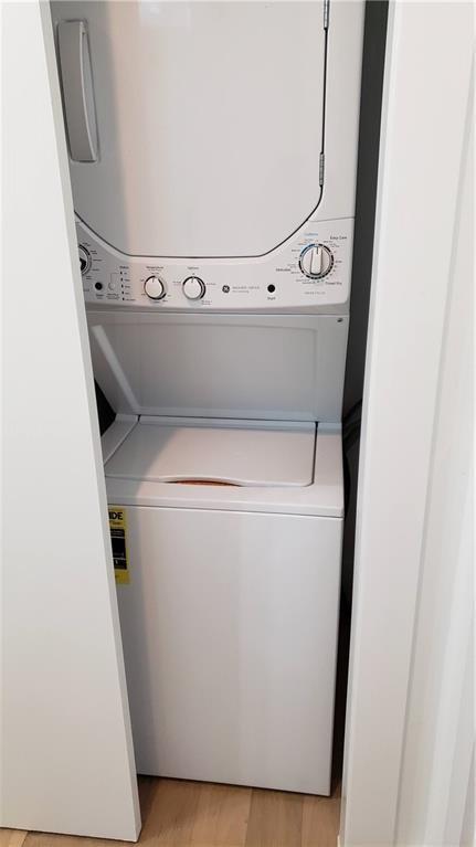 1614 Elmira Road Austin, TX 78721 - Photo 10 of 23 Washroom featuring estacked washer and dryer and light wood-style flooring