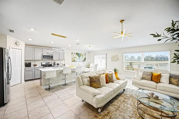 a living room with furniture and kitchen view