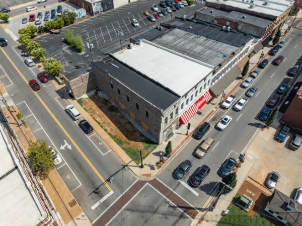 an aerial view of a house with a lot of residential buildings ocean and mountain view in back