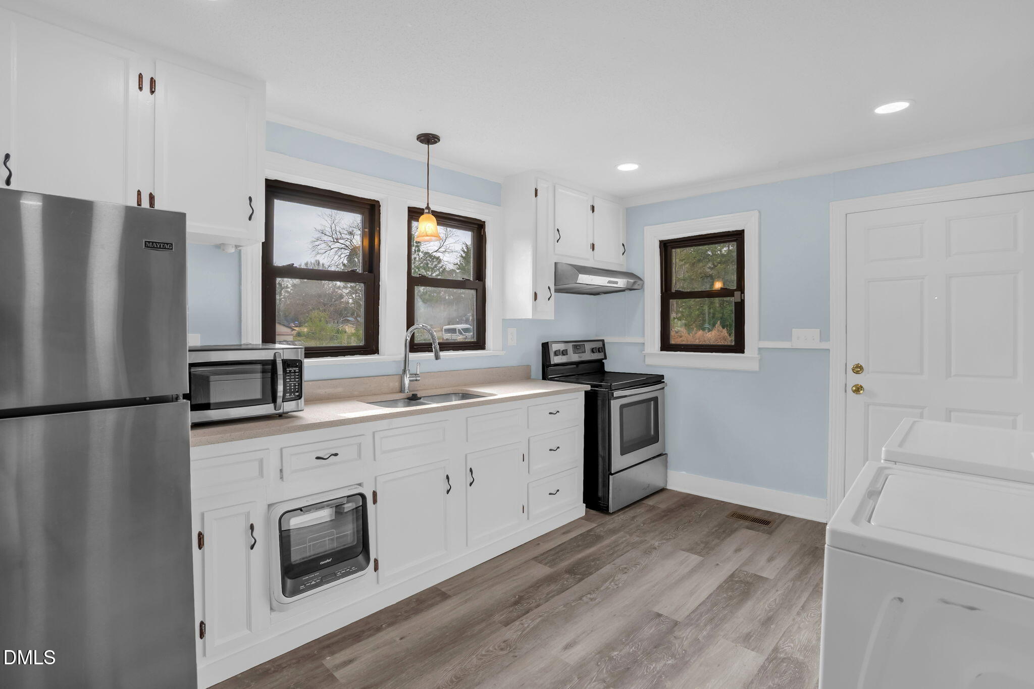 2807 Beck Road Durham, NC 27704 - Photo 17 of 35 a kitchen with white cabinets and stainless steel appliances